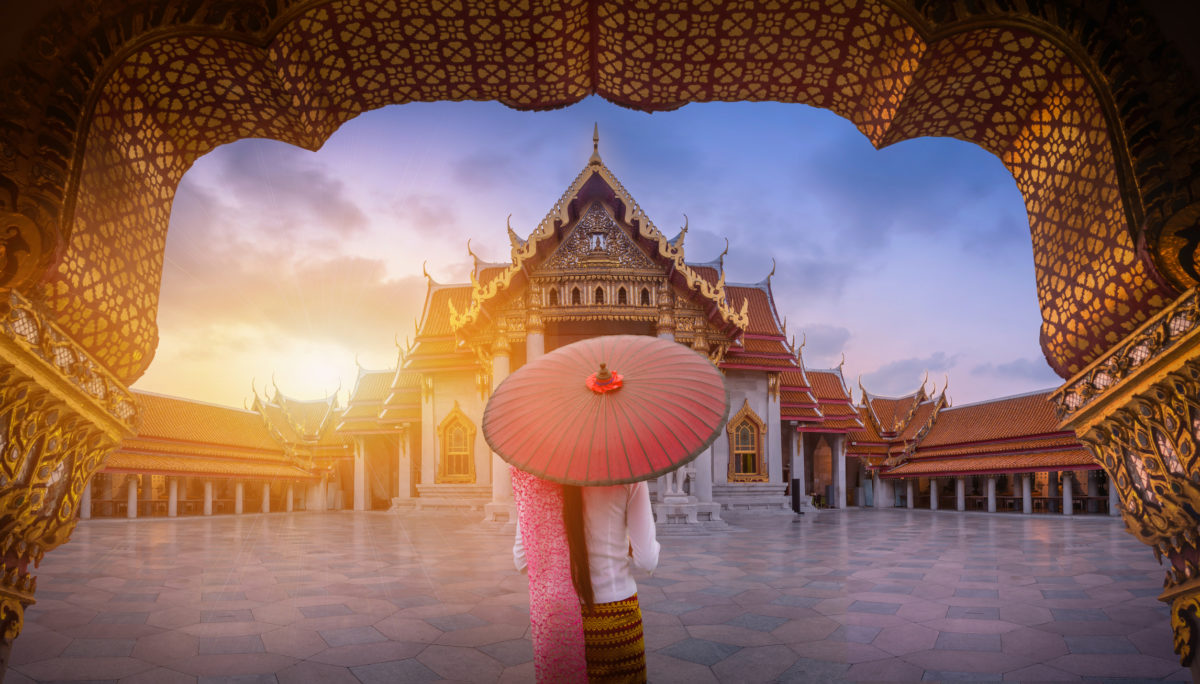 Woman holding traditional red umbrella on the Marble Temple, Wat bangkok Bangkok v top sezóne od 429€! Letíš z Viedne alebo Budapešti