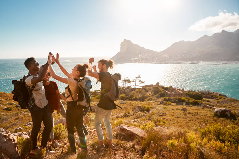 Young,Adult,Friends,On,A,Hike,Celebrate,Reaching,A,Summit 10 najpriateľskejších miest na svete. Tu sa turisti cítia najlepšie