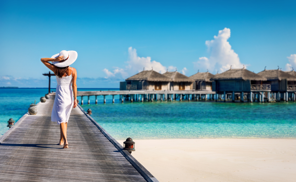 Woman,In,White,Walking,Over,A,Wooden,Jetty,In,The Maldivy otvoria budúci rok až 22 nových hotelových rezortov