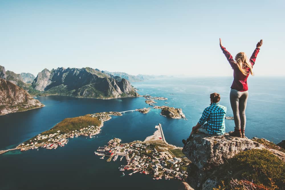 Couple,Family,Traveling,Together,On,Cliff,Edge,In,Norway,Man lofoty cestovatelia