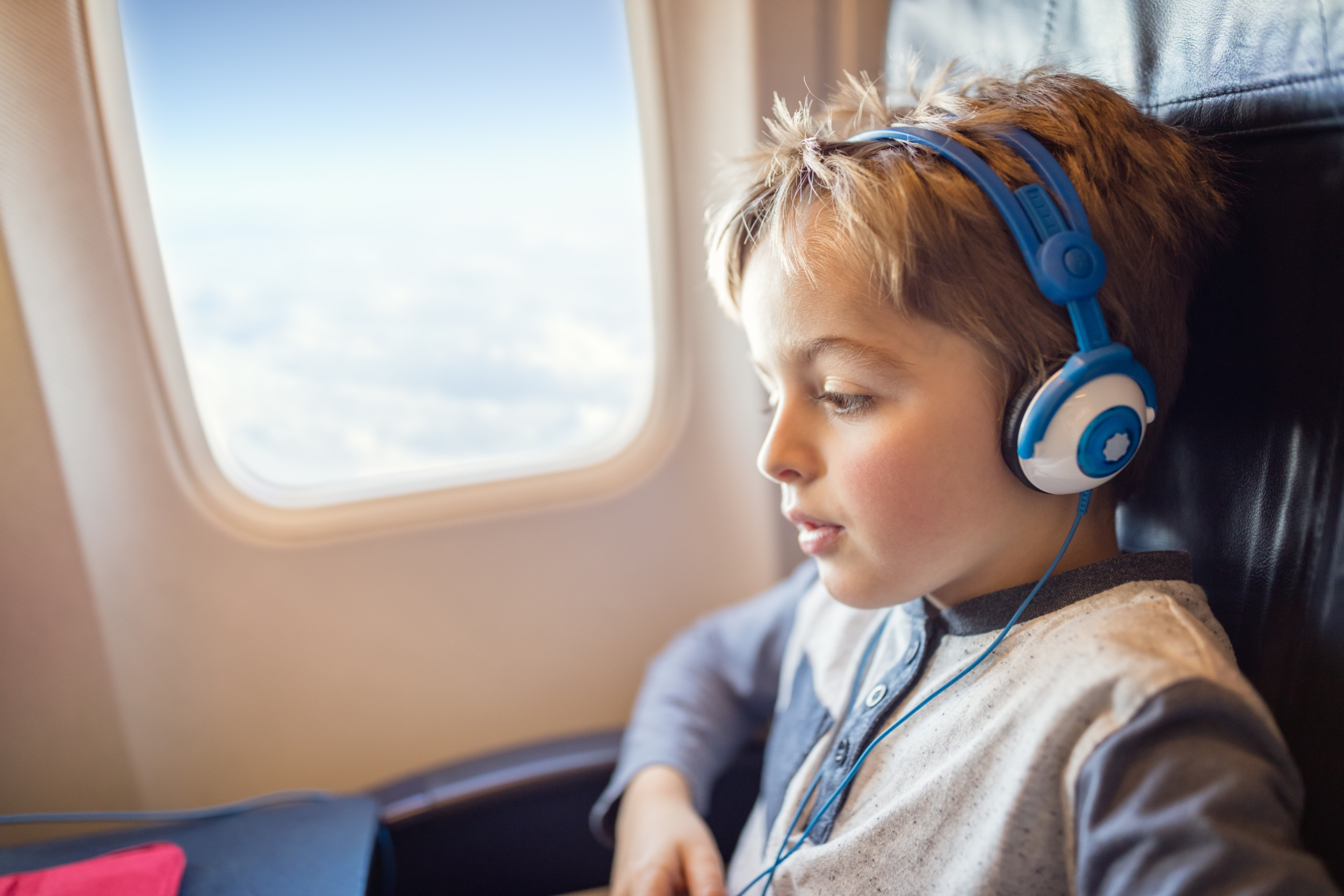 Boy,With,Headphones,Watching,And,Listening,To,In,Flight,Entertainment Cestovanie s deťmi: tipy, ako hravo zvládnete aj náročnú cestu